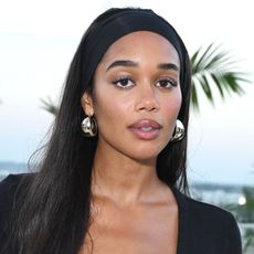 Laura Harrier wears a black headband and silver earrings