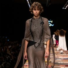 Louis Vuitton model wearing sheer striped dress on the runway