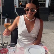 Woman in white top and necklace