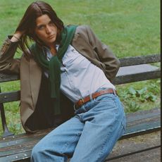 Woman in blazer, sweater, and jeans